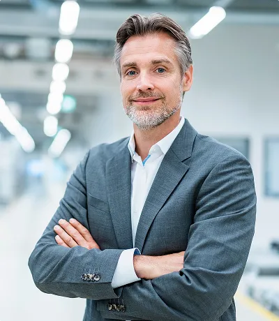 A man in a suit stands in a modern office lobby